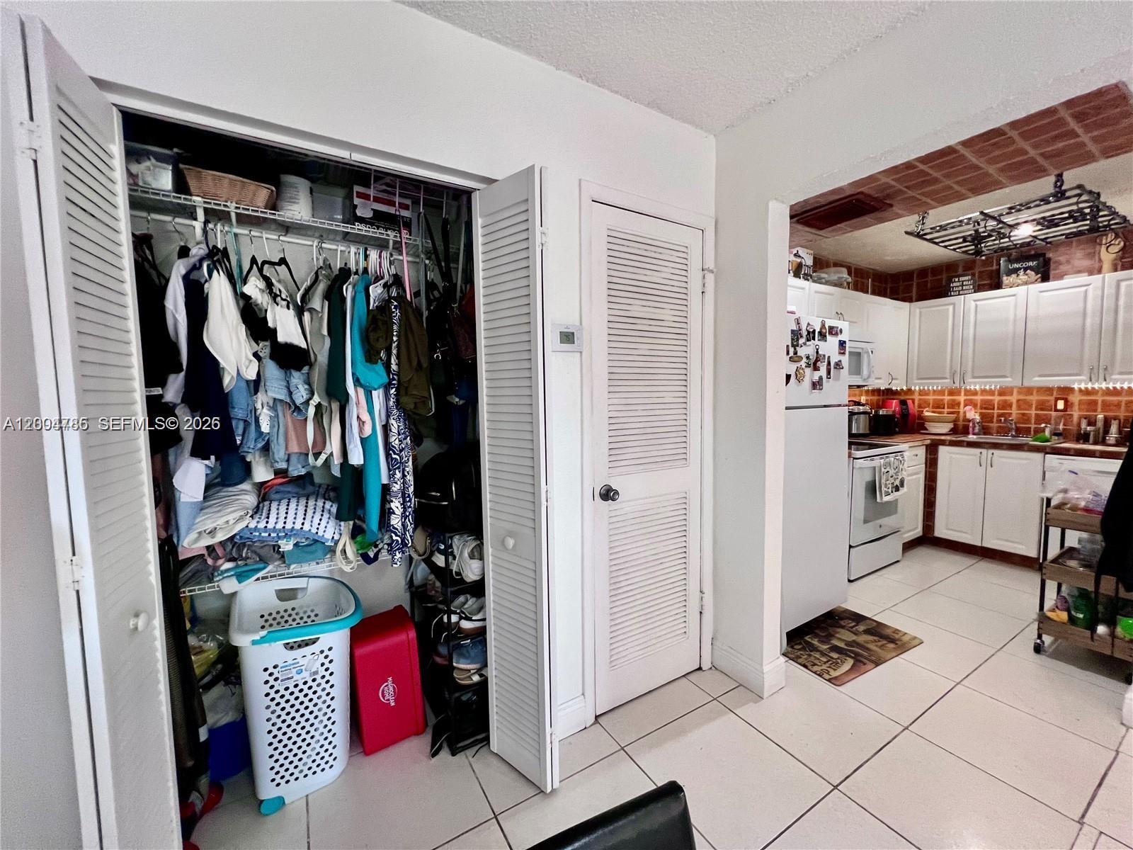 17530 Northwest 68th Avenue, Unit C4008 Hialeah, FL 33015 - Photo 17 of 26 a view of walk in closet with clothes and shoes