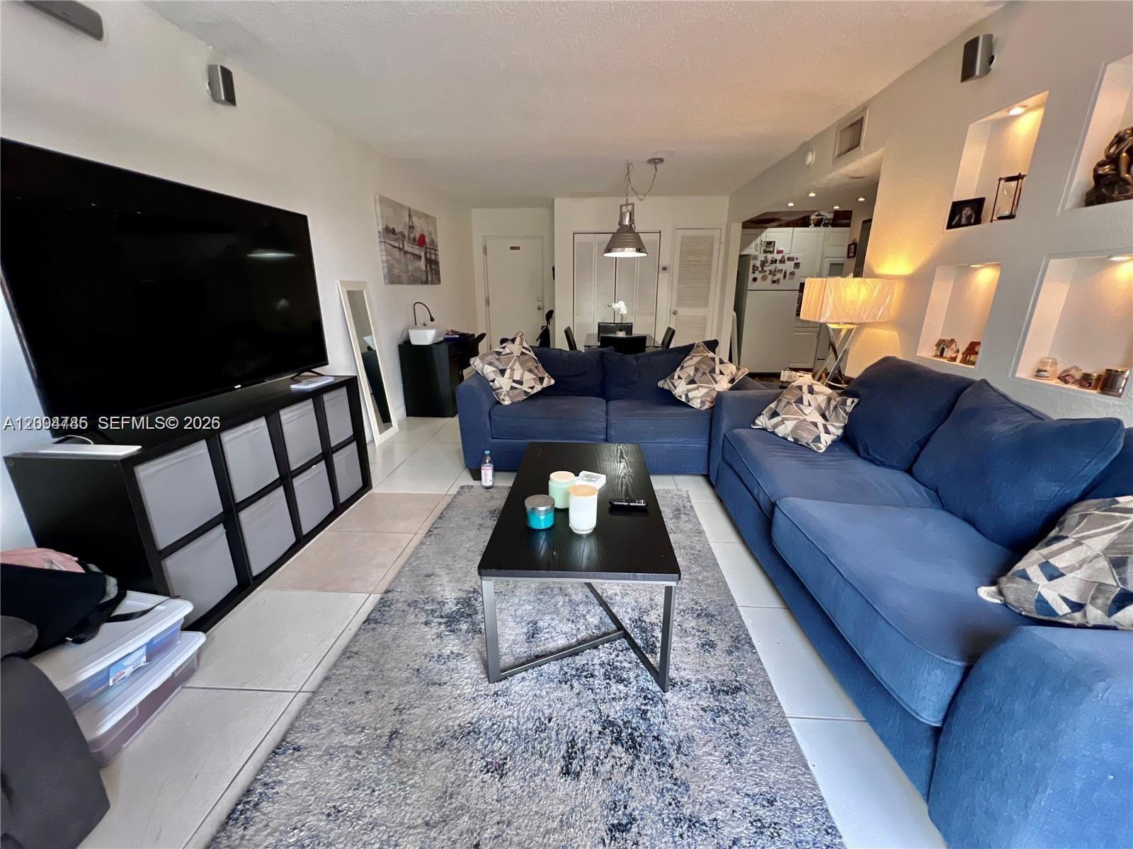 17530 Northwest 68th Avenue, Unit C4008 Hialeah, FL 33015 - Photo 6 of 26 a living room with furniture and a flat screen tv