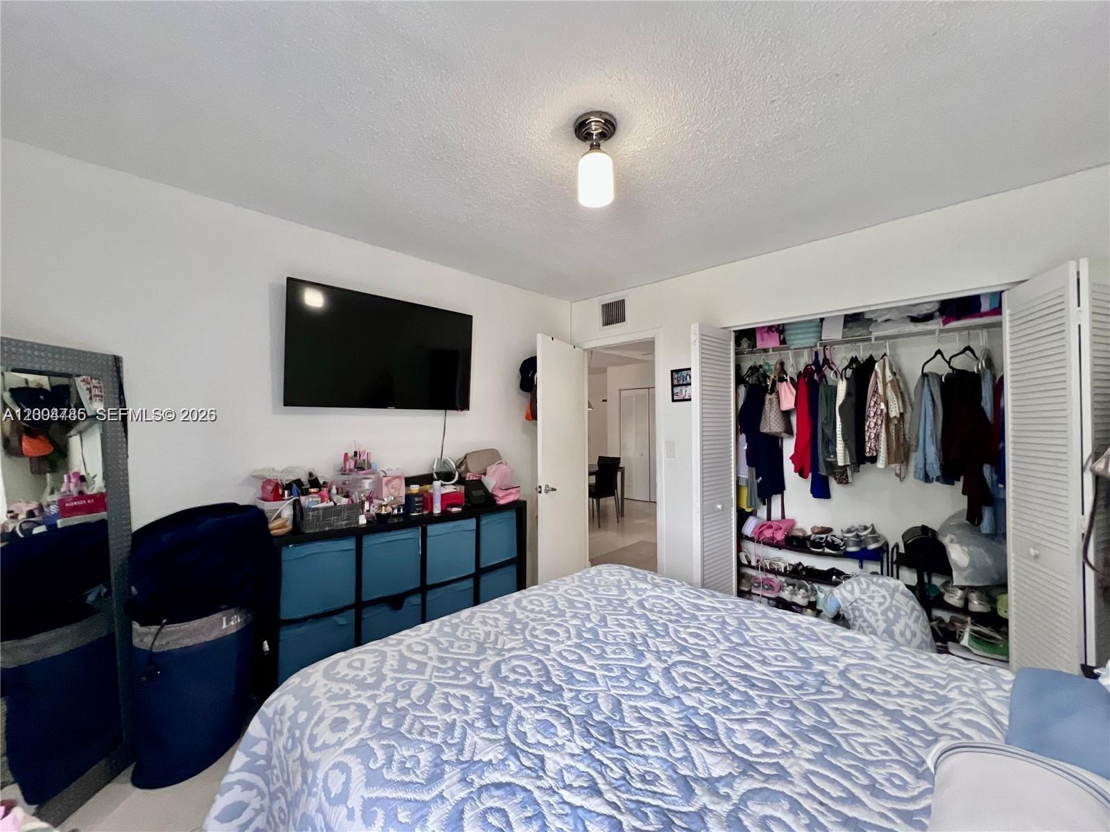 17530 Northwest 68th Avenue, Unit C4008 Hialeah, FL 33015 - Photo 8 of 26 a bedroom with a bed and a flat tv screen