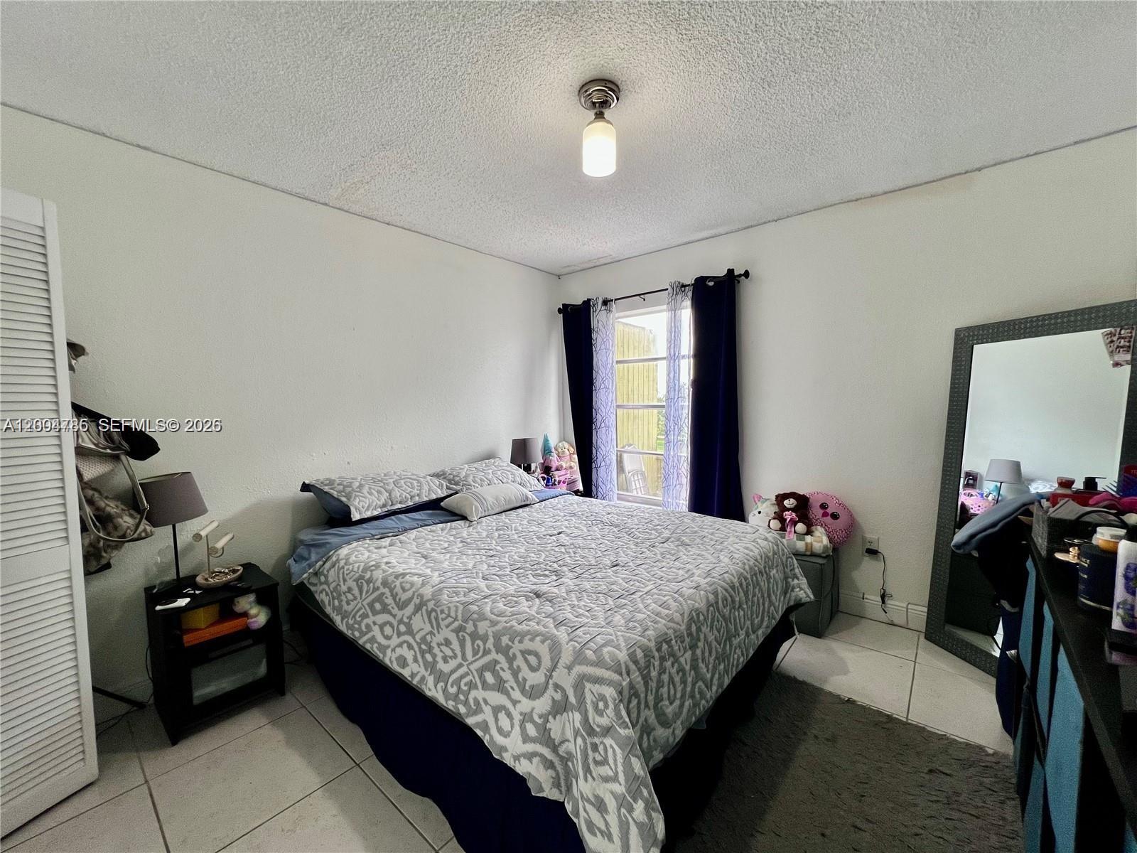 17530 Northwest 68th Avenue, Unit C4008 Hialeah, FL 33015 - Photo 9 of 26 a bedroom with bed and window