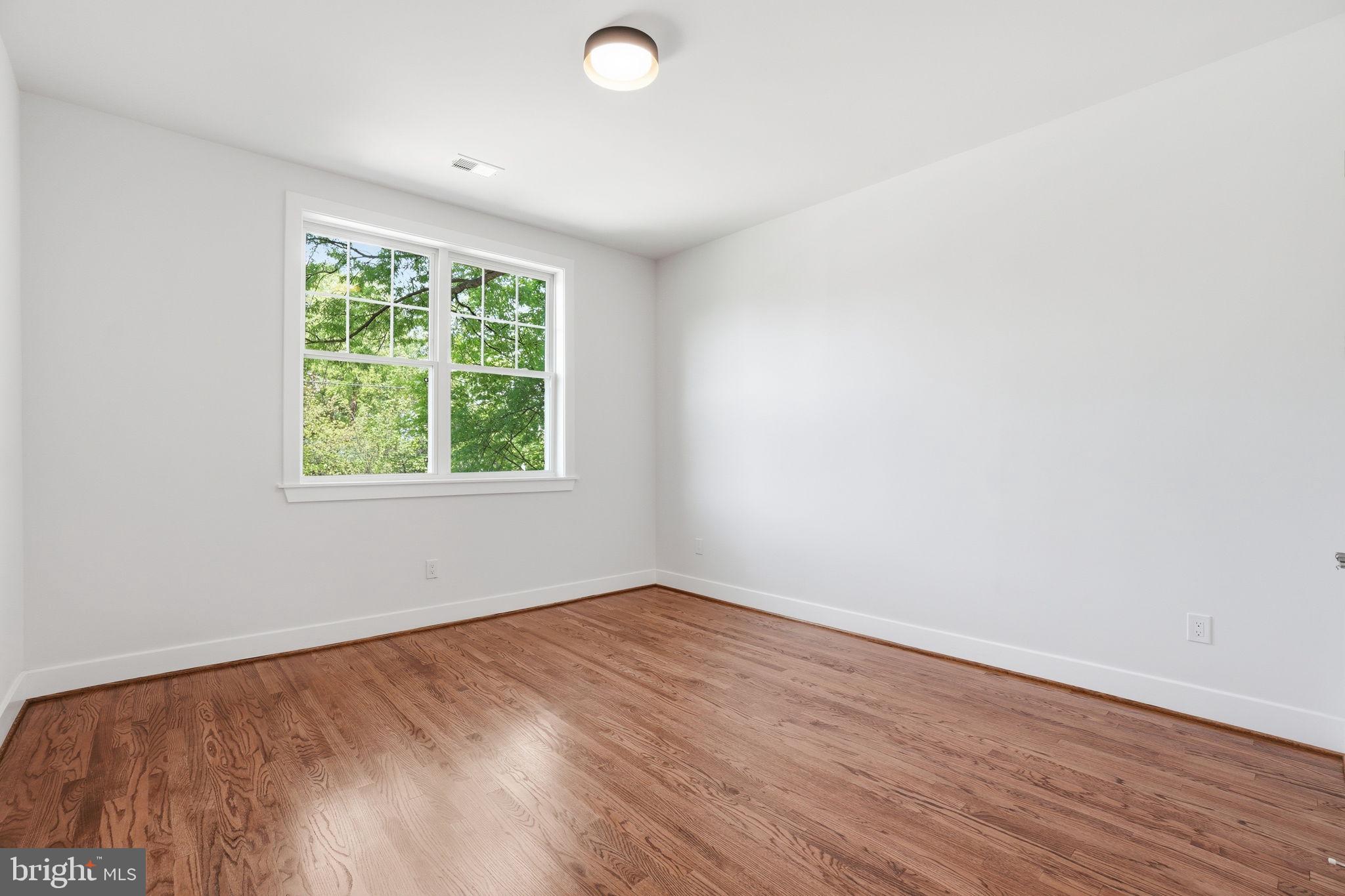4720 Ellicott Street Northwest Washington, DC 20016 - Photo 30 of 52 an empty room with wooden floor and windows