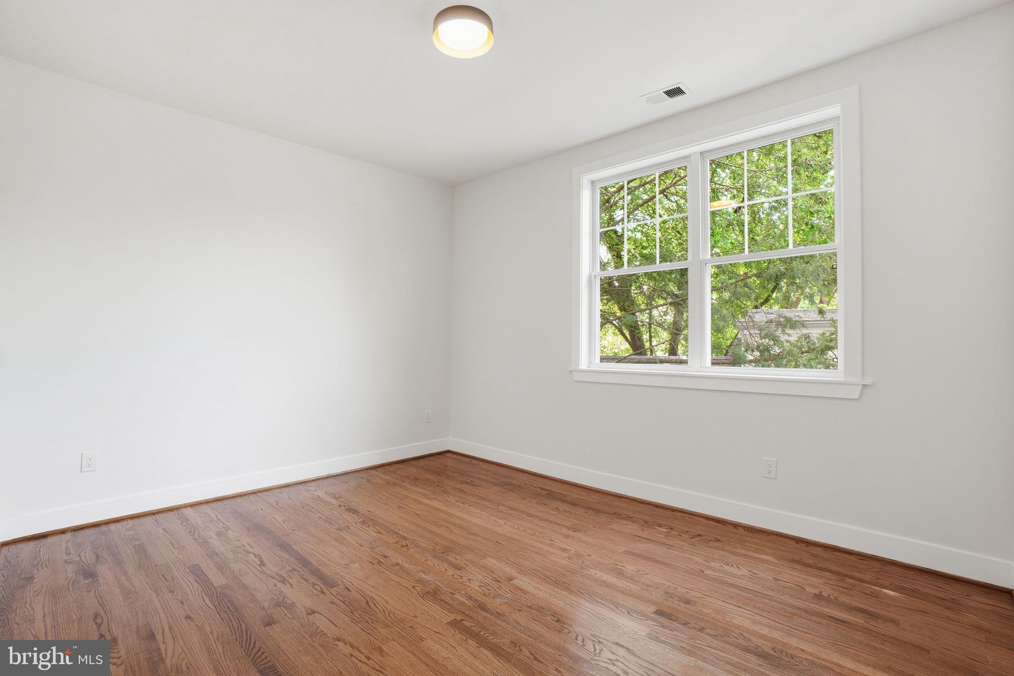 4720 Ellicott Street Northwest Washington, DC 20016 - Photo 32 of 52 an empty room with wooden floor and windows