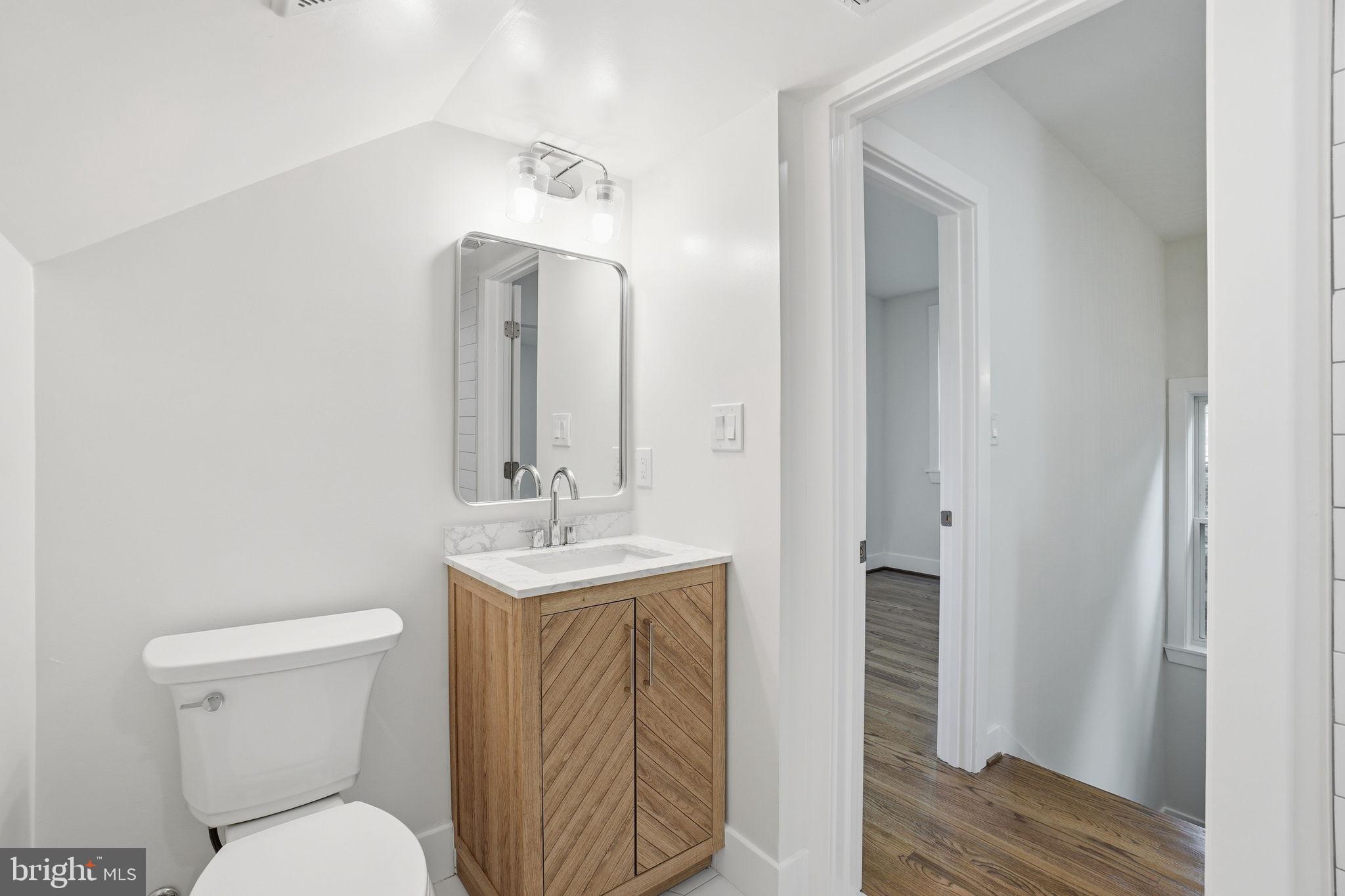 4720 Ellicott Street Northwest Washington, DC 20016 - Photo 38 of 52 a bathroom with a toilet a sink and mirror