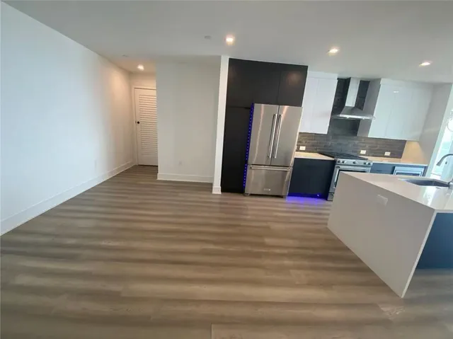 a view of a refrigerator in kitchen and wooden floor