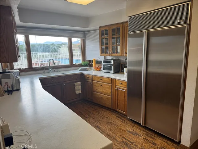 a kitchen with stainless steel appliances granite countertop a refrigerator a sink a stove and cabinets