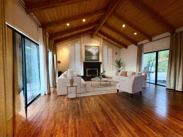 a view of an empty room with wooden floor and stairs
