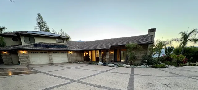 a front view of a house with a yard and potted plants