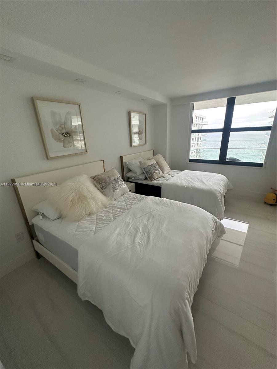 9801 Collins Avenue, Unit 19P Bal Harbour, FL 33154 - Photo 8 of 10 a bed sitting in a bedroom next to a window