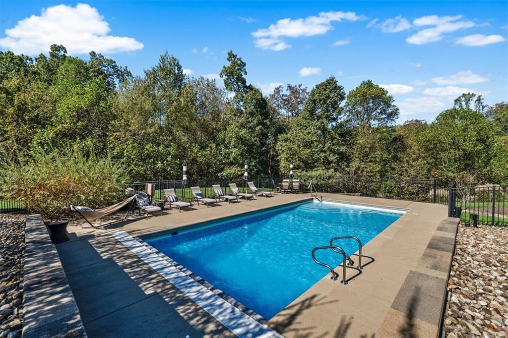 204 Durrow Court Mars, PA 16046 - Photo 8 of 24 a view of a swimming pool with lawn chairs under an umbrella