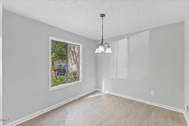 a view of empty room with window and ceiling fan