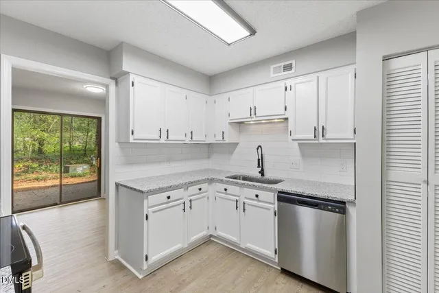 a kitchen with a sink stove and cabinets