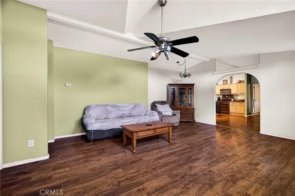 a kitchen with stainless steel appliances kitchen island granite countertop a refrigerator a stove top oven a sink dishwasher and white cabinets with wooden floor