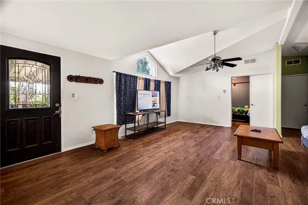 a view of an empty room with window and ceiling fan