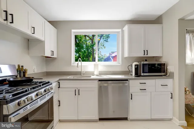 a bathroom with a granite countertop sink a toilet a mirror and bathtub