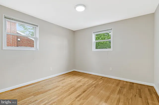 a kitchen with stainless steel appliances white cabinets and wooden floor