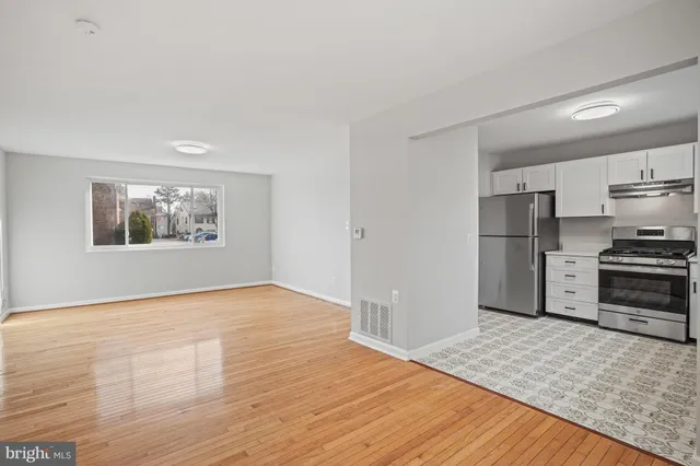 a kitchen with granite countertop a refrigerator and a stove top oven