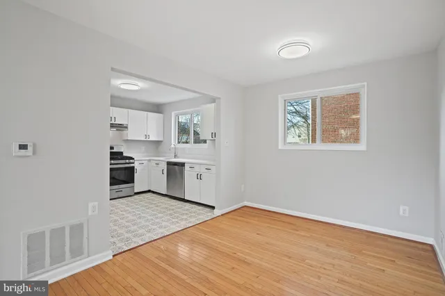 a view of a kitchen with wooden floor electronic appliances and windows