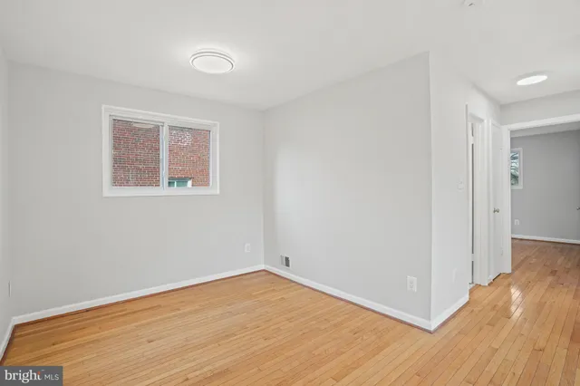a view of a room with wooden floor and a window
