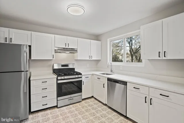 a kitchen with white cabinets and white appliances