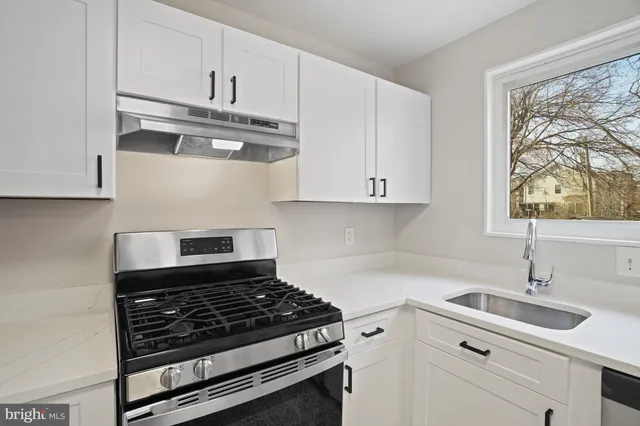 a kitchen with stainless steel appliances white cabinets and a stove