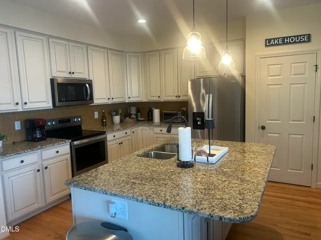 a kitchen with granite countertop a sink and cabinets