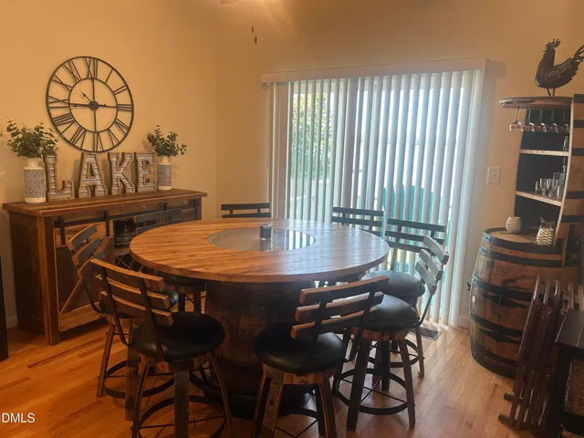 a table with chairs and a stove with wooden floor