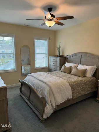 a bedroom with a bed chandelier and a window