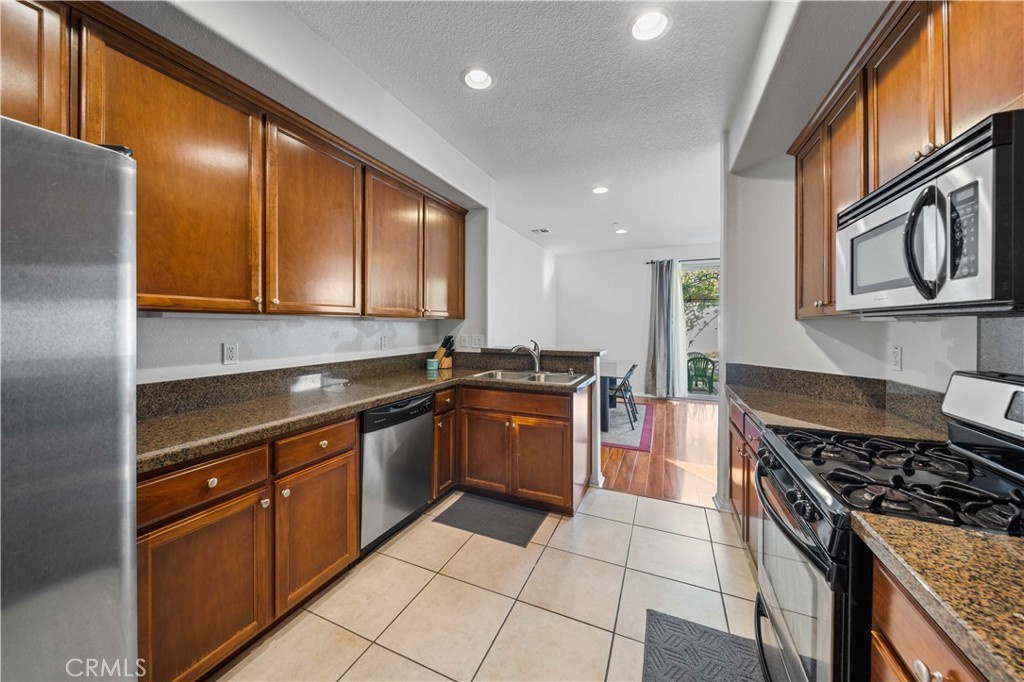 9352 Condor Court Pacoima, CA 91331 - Photo 10 of 23 a kitchen with stainless steel appliances granite countertop a stove a sink and a microwave