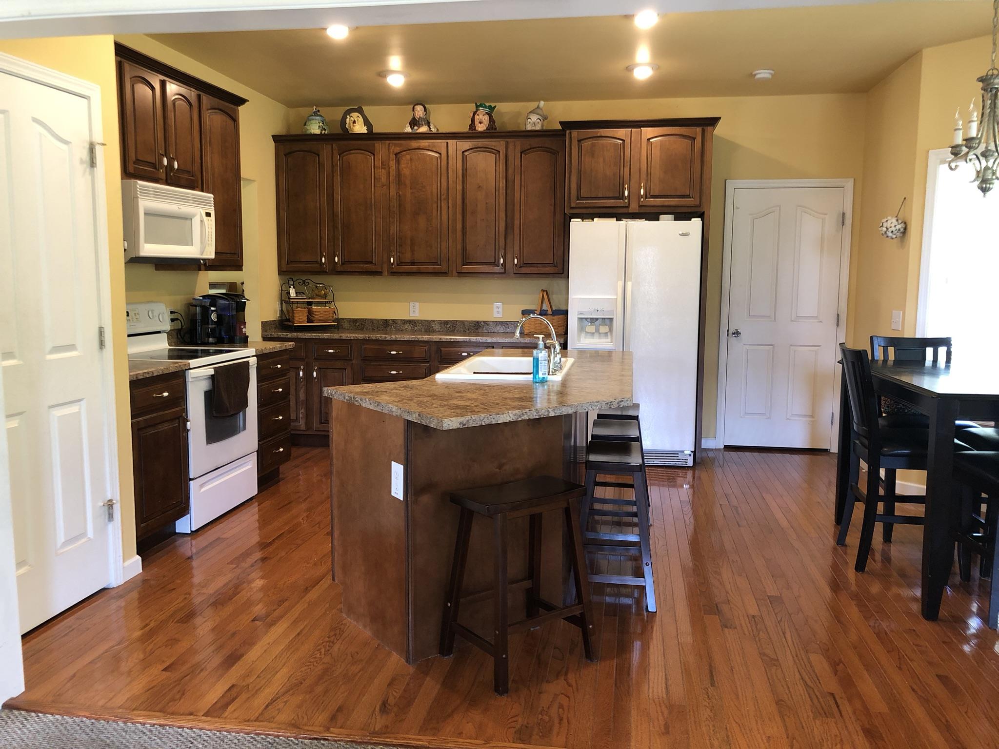3046 Wayside Road Manchester, TN 37355 - Photo 9 of 30 a kitchen with wooden floors and wooden cabinets
