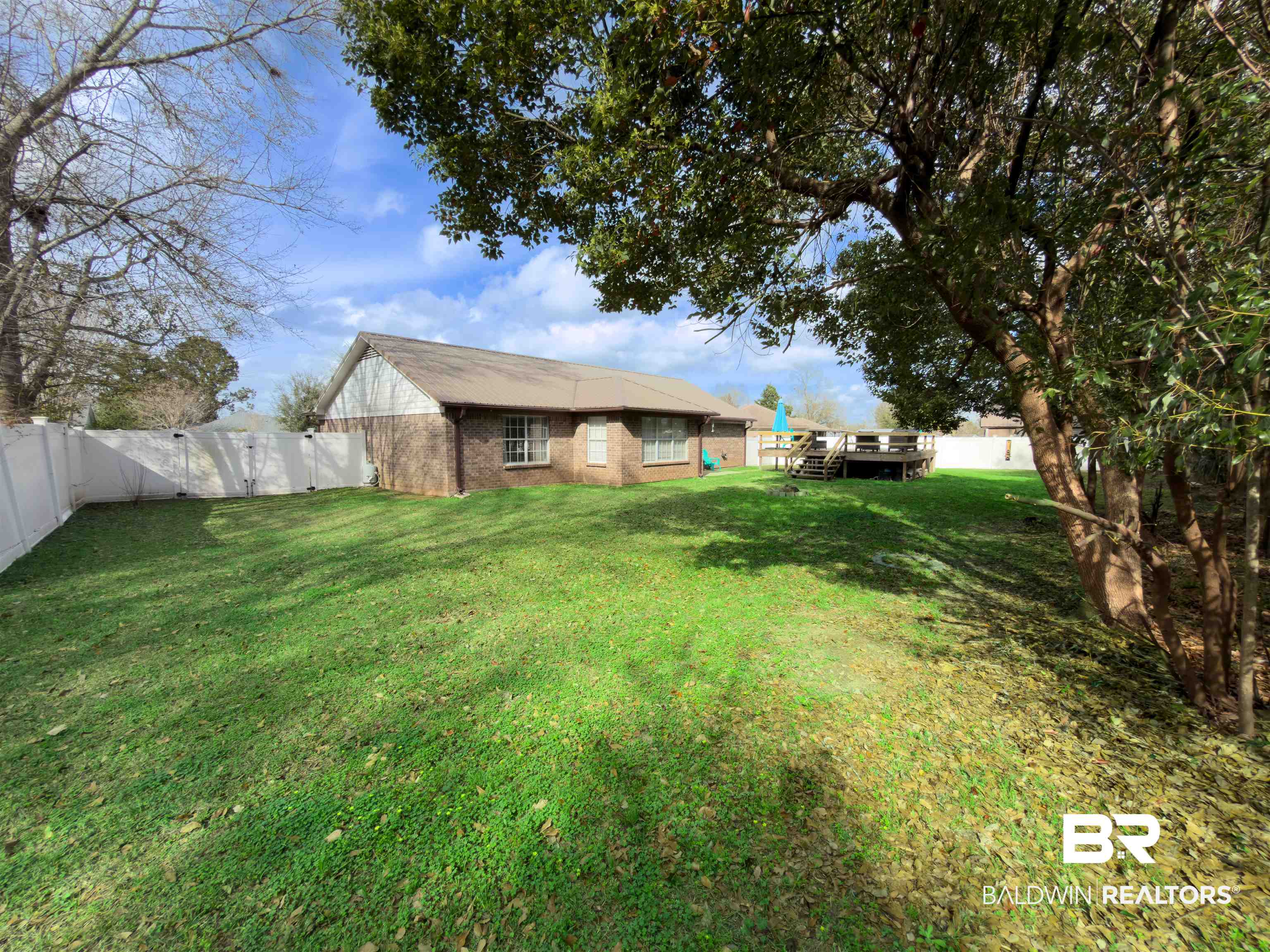 129 Pennbrooke Loop Foley, AL 36535 - Photo 40 of 44 Back of property featuring a fenced backyard, brick siding, and a deck