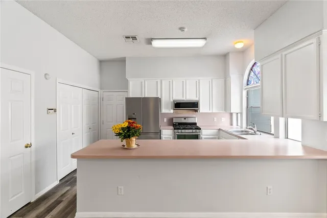 a kitchen with stainless steel appliances a sink a stove and a refrigerator