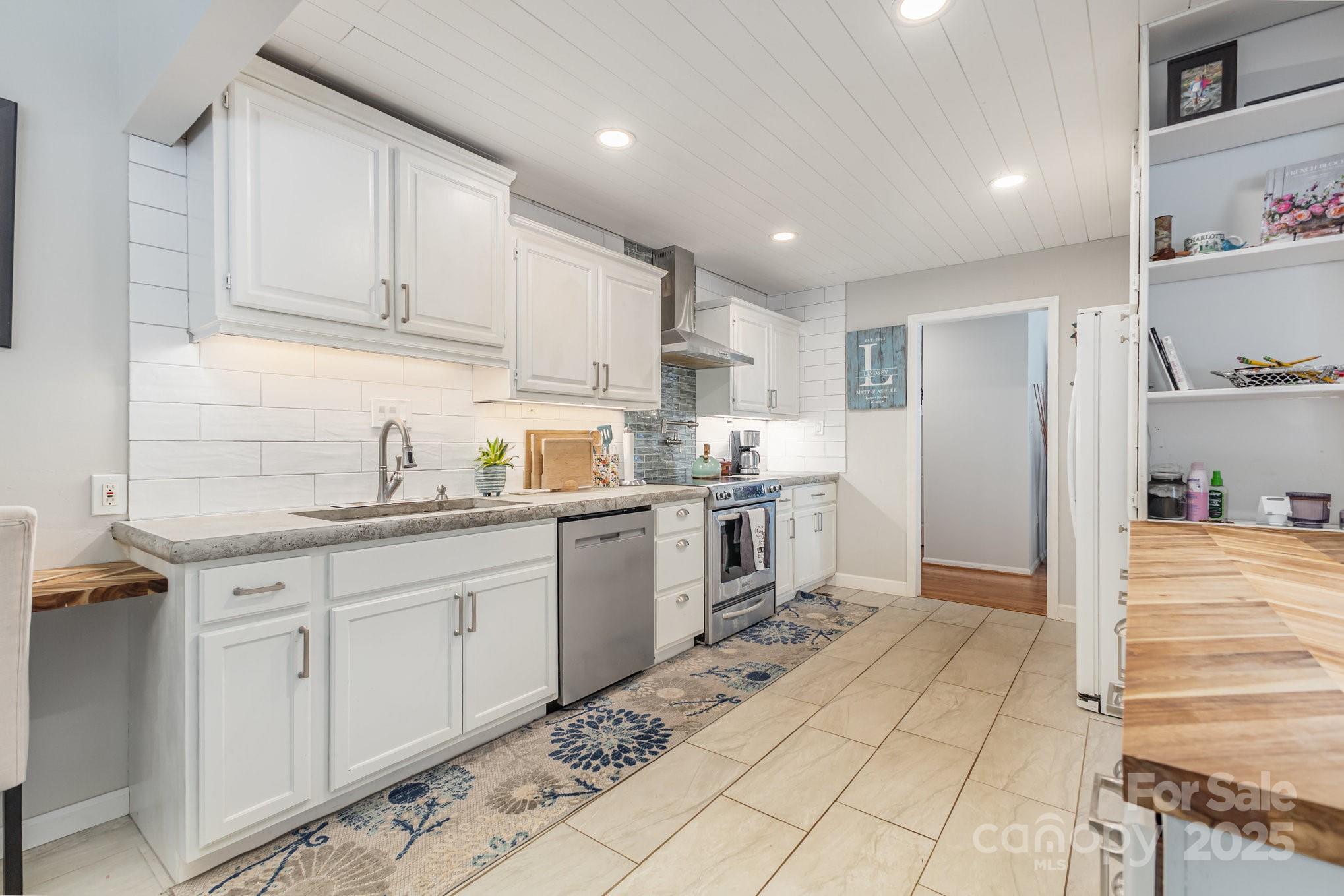 7042 Chelsea Day Lane Tega Cay, SC 29708 - Photo 8 of 40 a kitchen with granite countertop white cabinets and white appliances