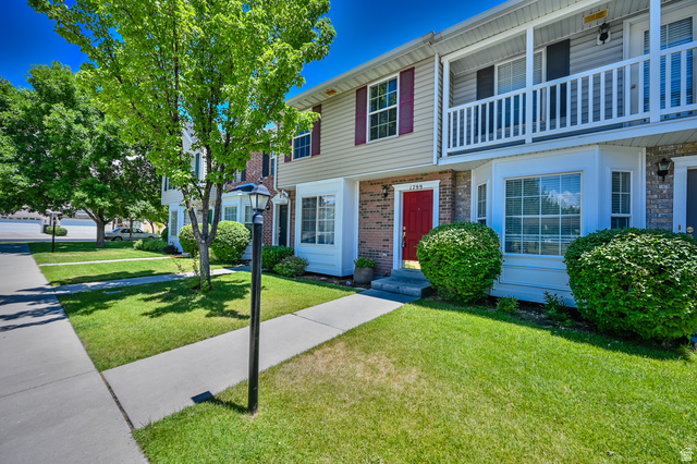 1799 West 1110th Street North Provo, UT 84604 - Photo 3 of 24 Brick and siding exterior featuring a prominent red entry door, an upper-level balcony with white railing, and a bay window