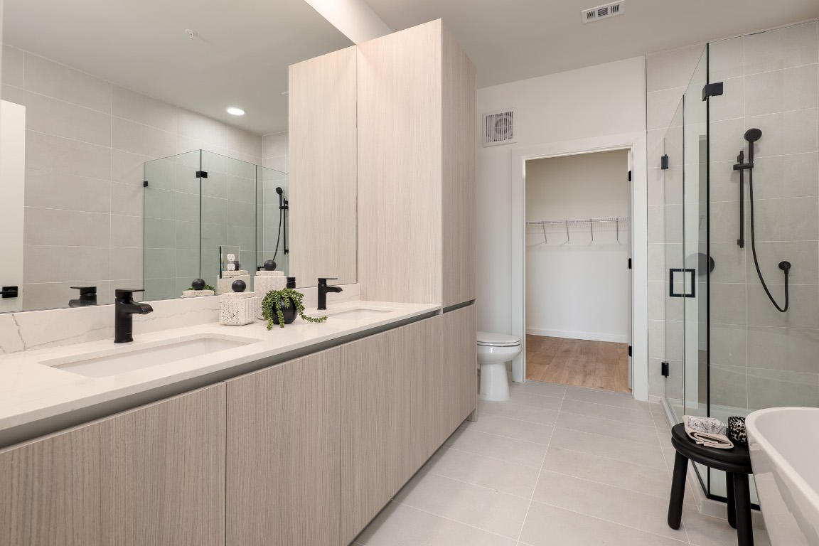 2209 South 1st Street, Unit 334 Austin, TX 78704 - Photo 13 of 28 a bathroom with a double vanity sink a toilet and a shower