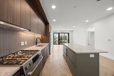 a large kitchen with stainless steel appliances granite countertop a stove and a sink