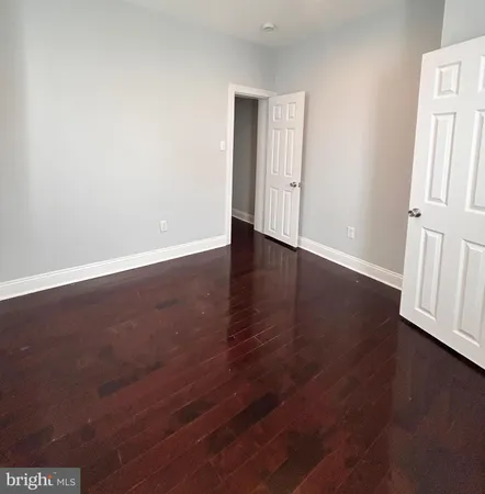 an empty room with wooden floor and door