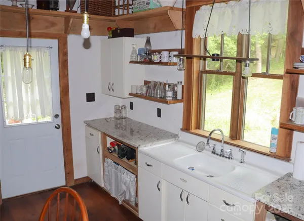 a bathroom with a granite countertop sink and a window