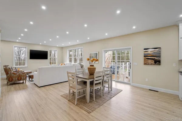 a living room with furniture a dining table and a flat screen tv