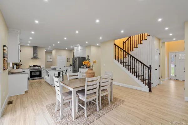 a kitchen with stainless steel appliances kitchen island granite countertop a table and chairs in it