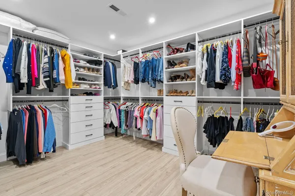 a view of walk in closet with clothes and shoes