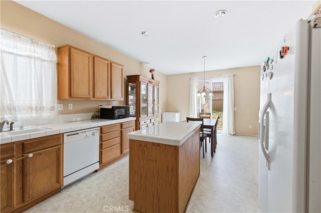 2822 Emerald Lane Lancaster, CA 93535 - Photo 12 of 29 a kitchen with kitchen island granite countertop a sink stove and refrigerator