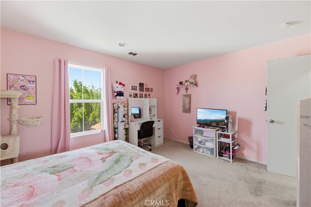 2822 Emerald Lane Lancaster, CA 93535 - Photo 18 of 29 a bedroom with a bed a desk and chair with a mirror