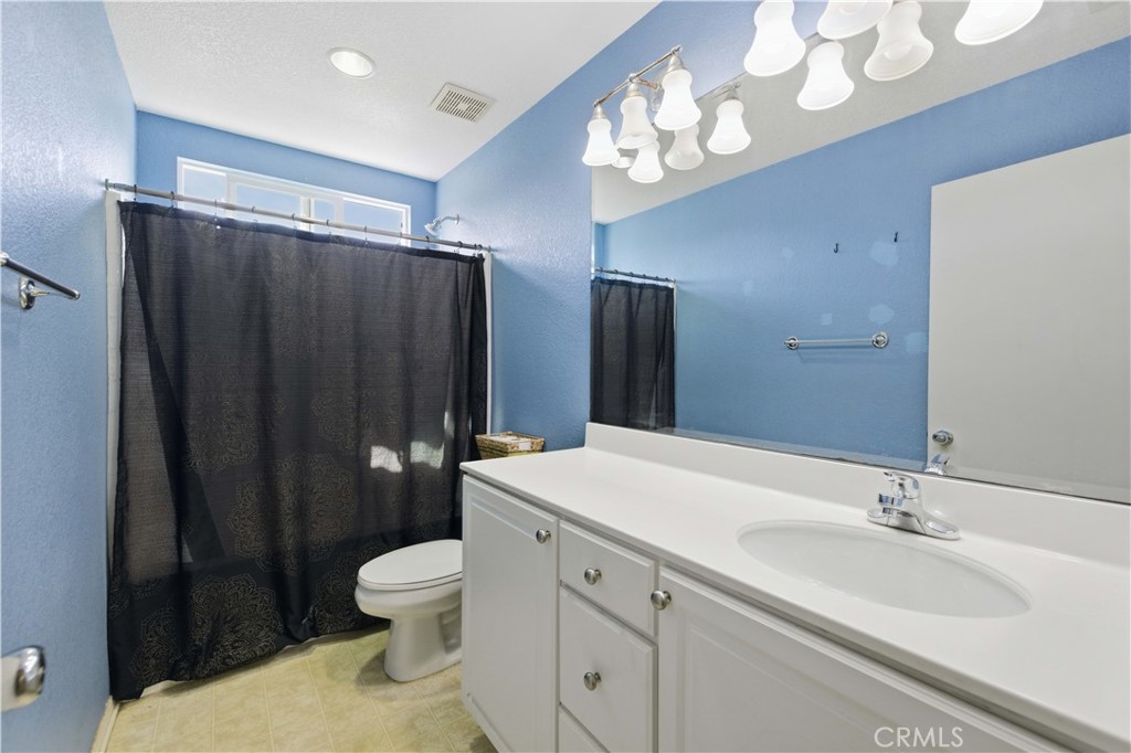 2822 Emerald Lane Lancaster, CA 93535 - Photo 20 of 29 a bathroom with a sink a toilet and a large mirror