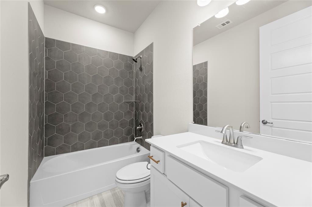 7216 Ladybug Lane Aubrey, TX 76227 - Photo 1 of 1 a bathroom with a granite countertop sink a toilet and bathtub