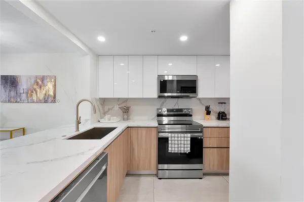 a kitchen with stainless steel appliances a stove microwave and sink