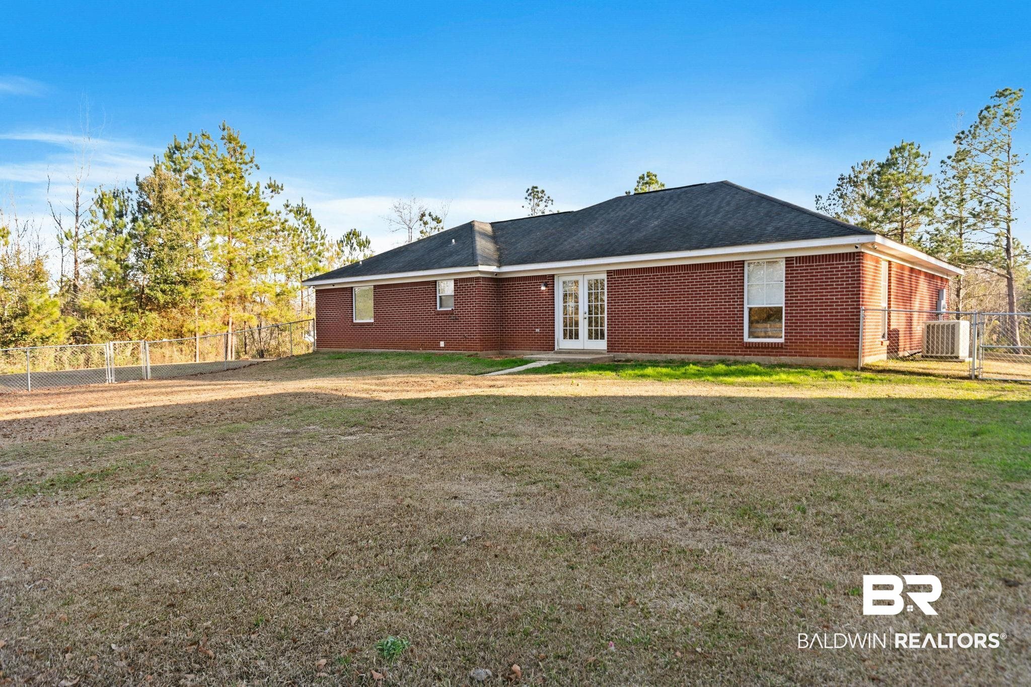 55750 Lottie Road Perdido, AL 36562 - Photo 34 of 84 Rear view of property featuring french doors, a fenced backyard, brick siding, and a gate