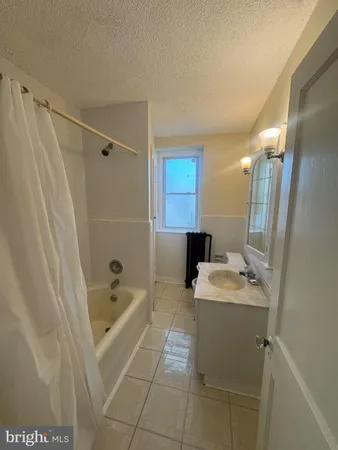 a bathroom with a sink a toilet a mirror and shower
