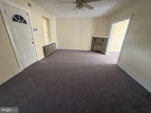 an empty room with a window and a ceiling fan