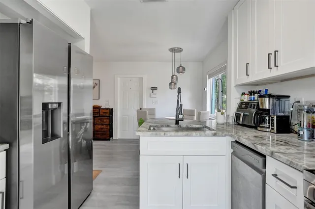 a kitchen with stainless steel appliances granite countertop a refrigerator and a sink