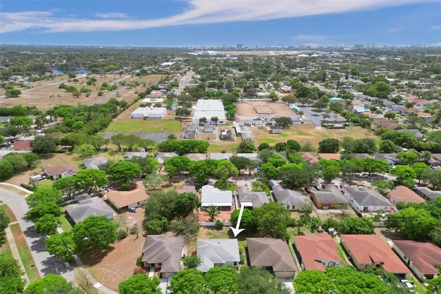 an aerial view of residential houses with outdoor space and trees